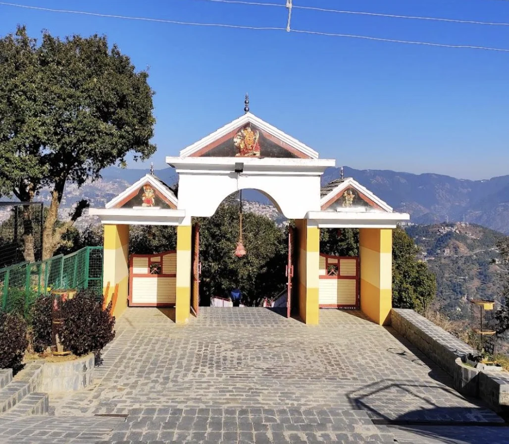The gate of Bhuvneshwari Devi Temple in Suwakholi near Mussoorie, with hills and valleys behind