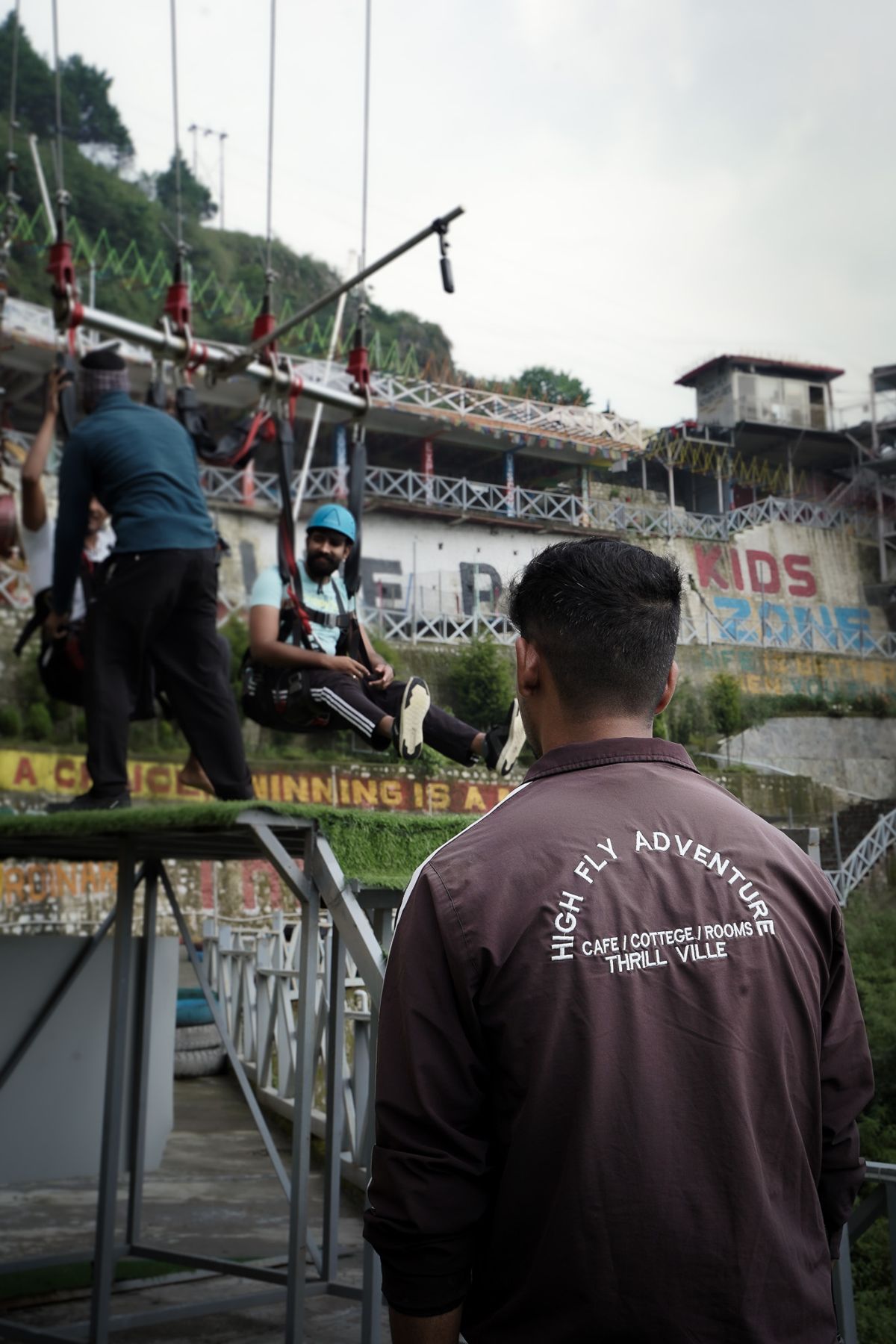 A High Fly Adventure team member in the brand jacket watching an activity in Suwakholi near Mussoorie
