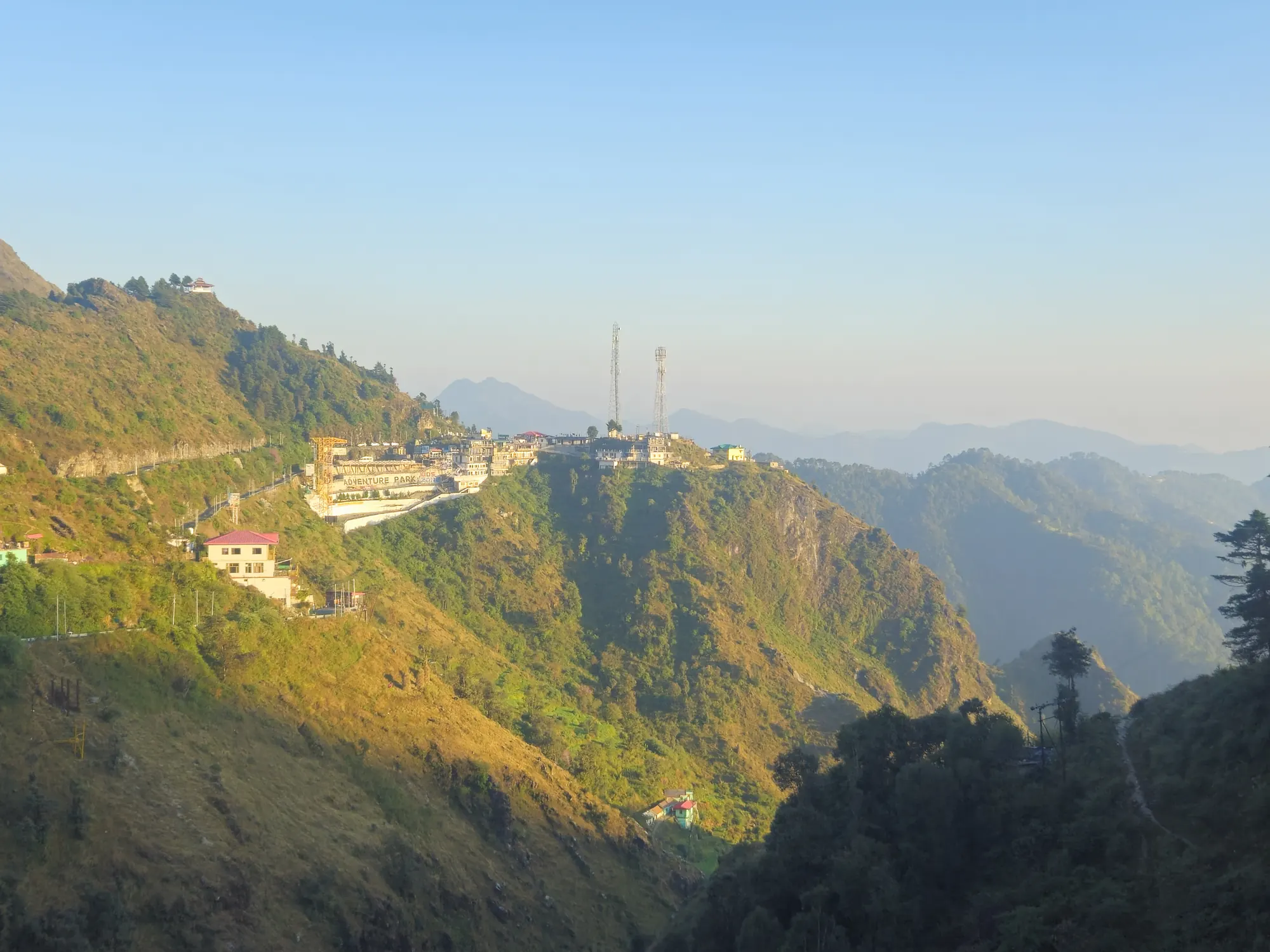 The Mussoorie and Landour ridge lit by afternoon sun, with forested valleys below