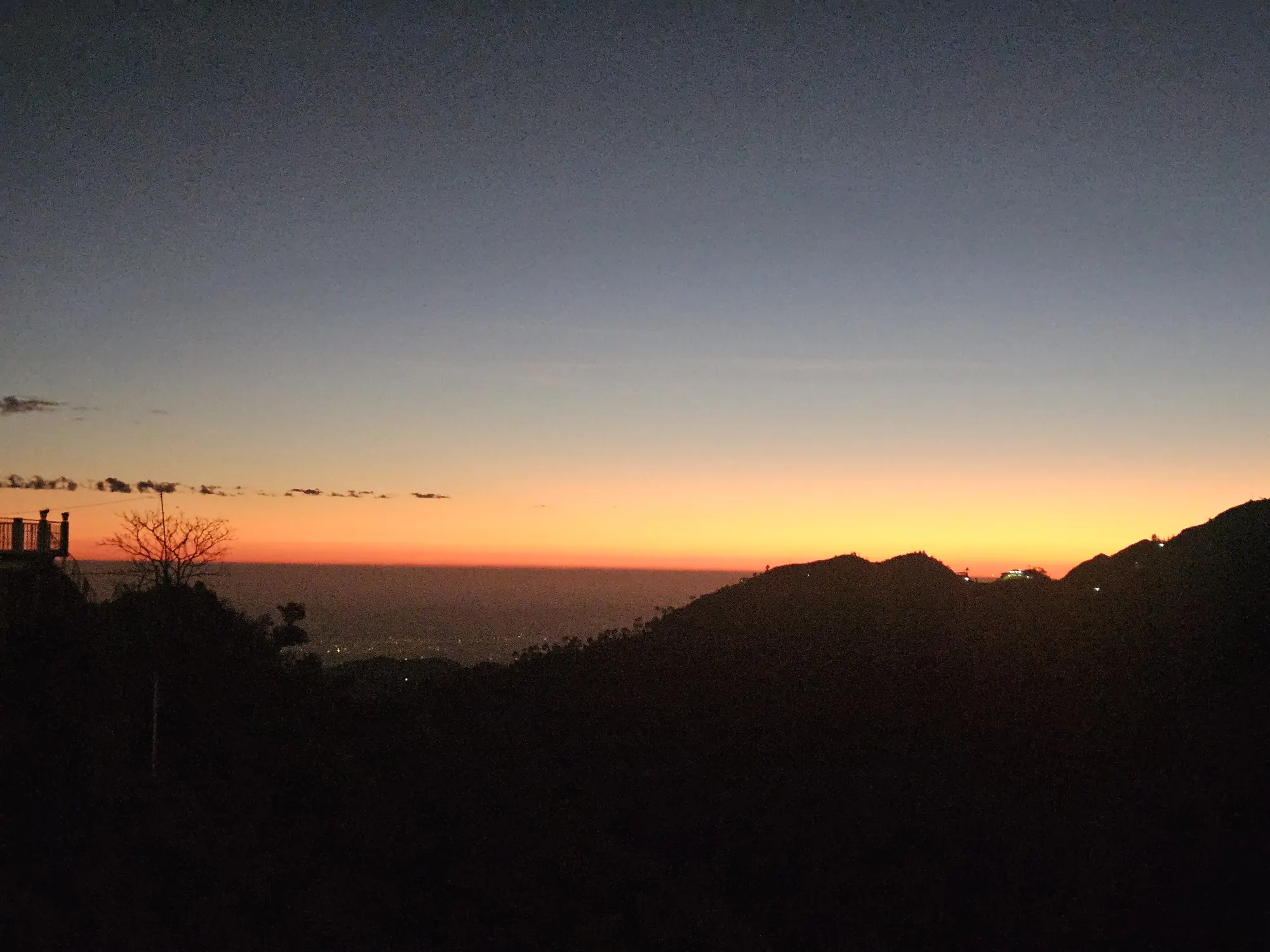 Orange band of light on the horizon after sunset, seen from the hills near Mussoorie in late October