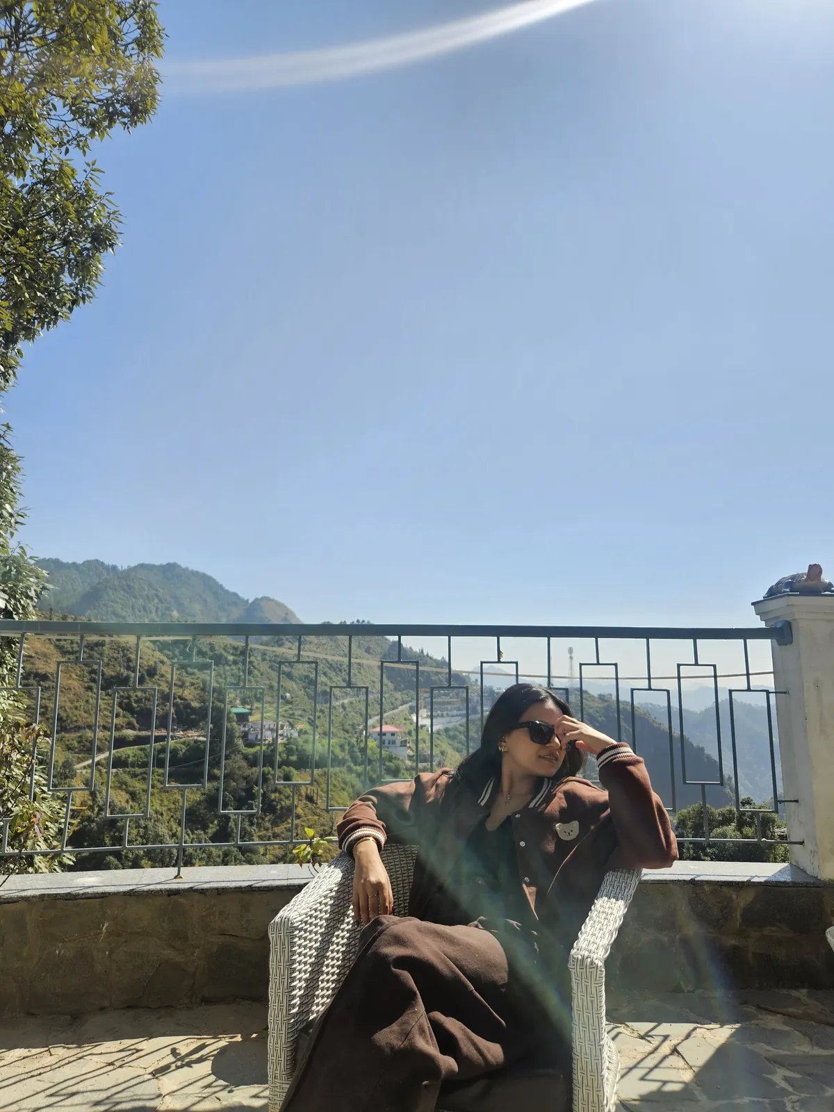 A traveller relaxing in the November sunshine on a balcony with a mountain view in Suwakholi