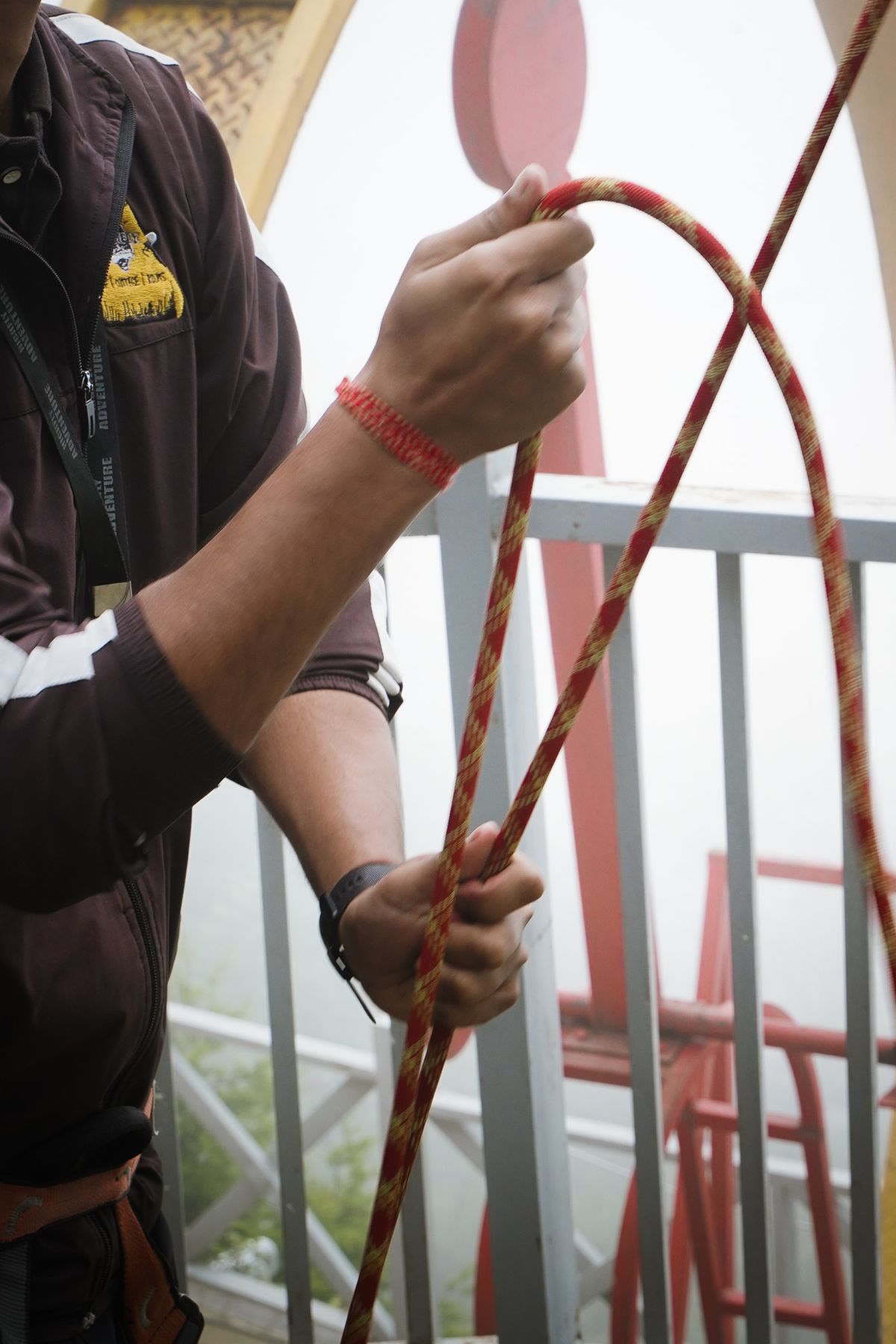 A High Fly Adventure team member coiling a safety rope during equipment checks in Suwakholi