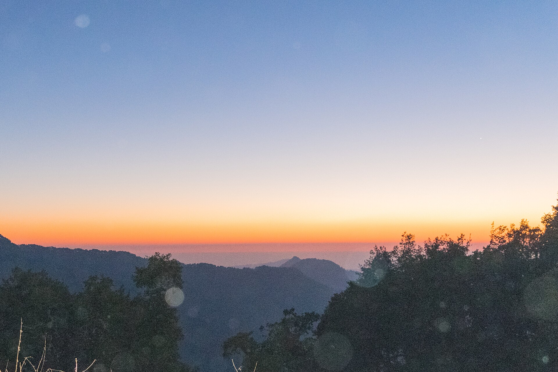 Winterline in Mussoorie: a thin orange band of light above the valley horizon after sunset